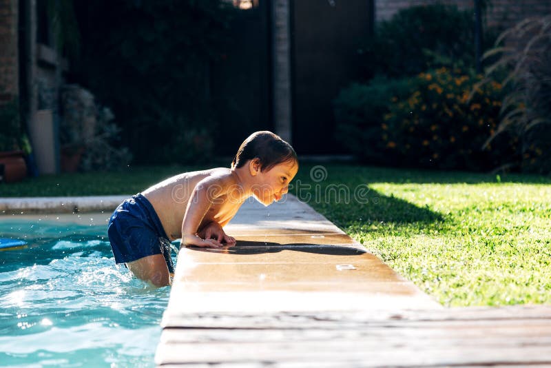 Little boy striving for get out of a swimming pool. Child learning to swim. Little boy striving for get out of a swimming pool. Child learning to swim.