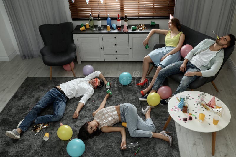 一群朋友在派对后睡在凌乱的房间里 库存图片