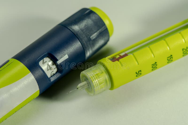 胰岛素笔模型和一次注射器或注射器与药量设置瘤和标度窗口的丢掉针以明亮的黄色 库存照片 胰岛素笔模型和一次注射器或注射器与药量设置瘤和标度窗口的丢掉针以明亮的黄色 库存照片