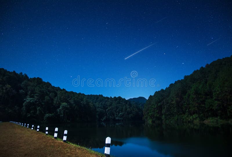 Beautiful views of nature at night with shooting star in northern Thailand dam. View. Beautiful views of nature at night with shooting star in northern Thailand dam. View.