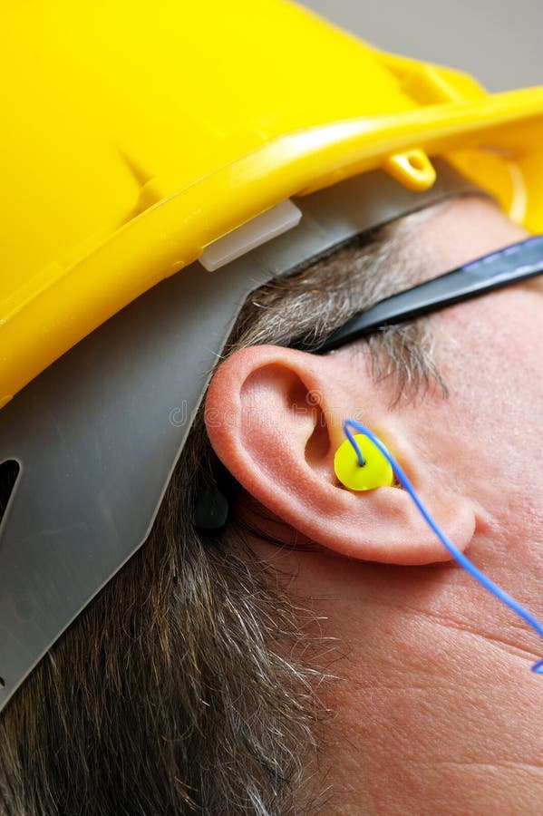 Yellow ear plug into the ear close up. Yellow ear plug into the ear close up