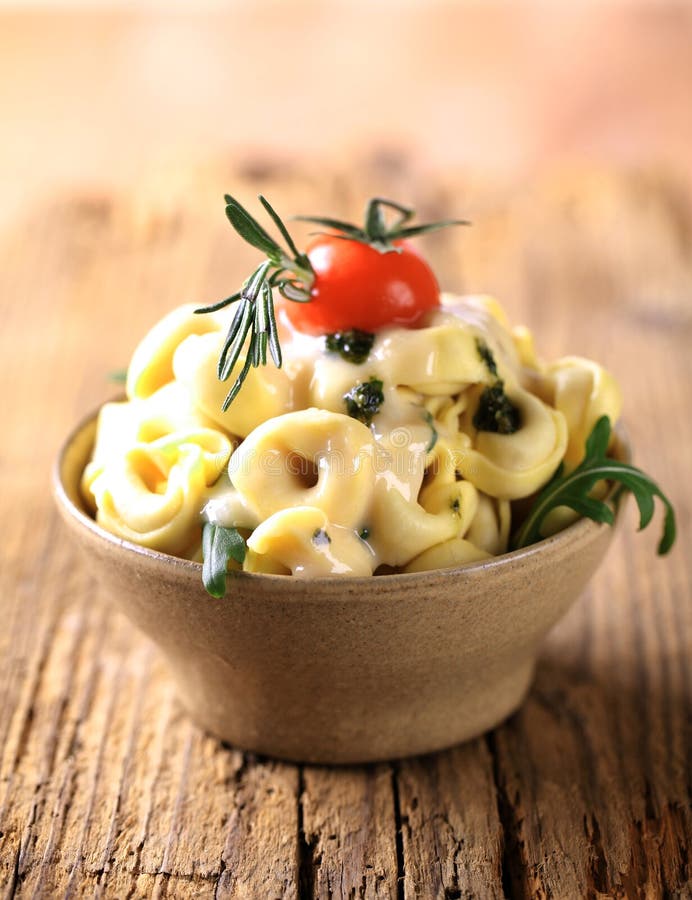 Tortellini with cheese sauce and arugula - detail. Tortellini with cheese sauce and arugula - detail