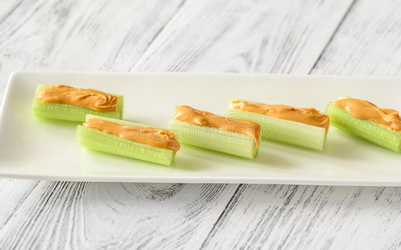 Celery stalks with peanut butter on serving plate. Celery stalks with peanut butter on serving plate