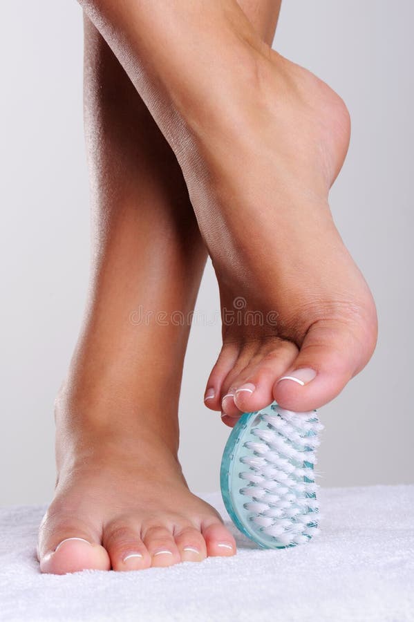 Beautiful well-groomed feet, stops of the young woman and pedicure cleaning brush. Beautiful well-groomed feet, stops of the young woman and pedicure cleaning brush