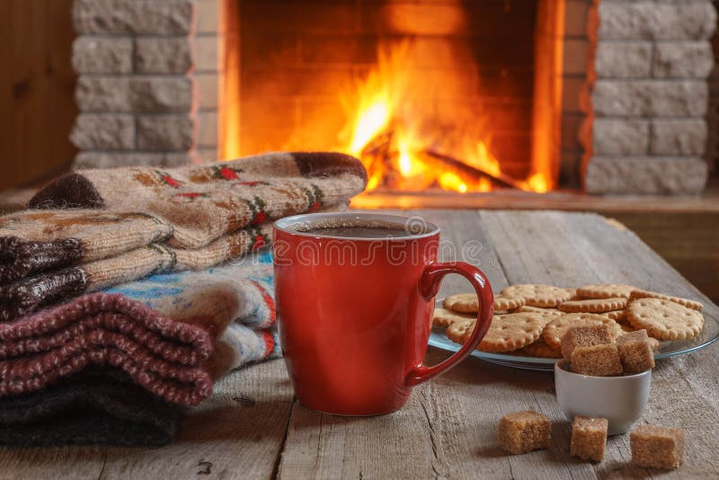茶或咖啡的橙色杯子;羊毛事临近舒适壁炉