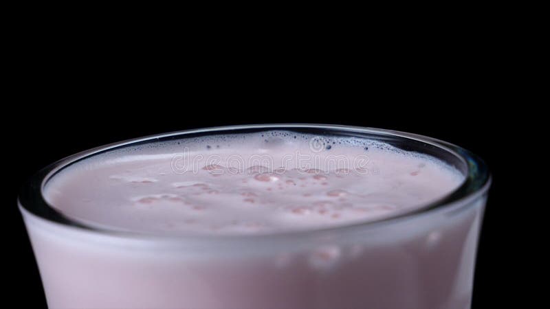 草莓奶昔特写镜头在黑被隔绝的背景的 ?? 与重泡沫和泡影的乳状桃红色鸡尾酒 图库摄影 草莓奶昔特写镜头在黑被隔绝的背景的 ?? 与重泡沫和泡影的乳状桃红色鸡尾酒 图库摄影