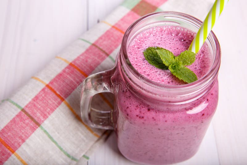 Berry milkshake or smoothie with ingredients and mint. Healthy drink in mason jar. Berry milkshake or smoothie with ingredients and mint. Healthy drink in mason jar.