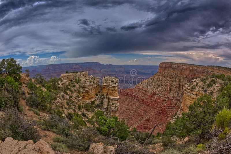 The rock island of Moran Point at Grand Canyon South Rim on a cloudy day. Zuni Point is just right of center in the distance. The rock island of Moran Point at Grand Canyon South Rim on a cloudy day. Zuni Point is just right of center in the distance