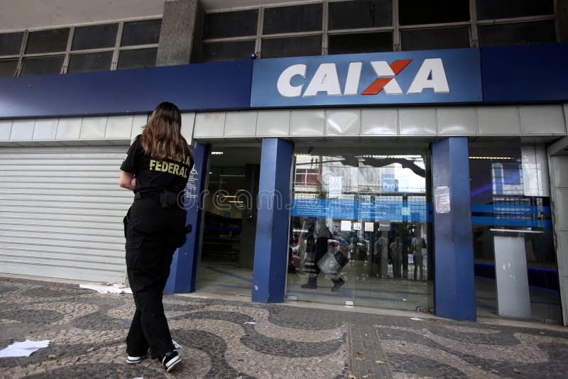 Salvador, bahia / brazil - october 2, 2017: Federal Police agent is seen during an investigation at Caixa Econômica Federal branch on Avenida Sete de Setembro in Salvador. The site was broken into overnight. Salvador, bahia / brazil - october 2, 2017: Federal Police agent is seen during an investigation at Caixa Econômica Federal branch on Avenida Sete de Setembro in Salvador. The site was broken into overnight