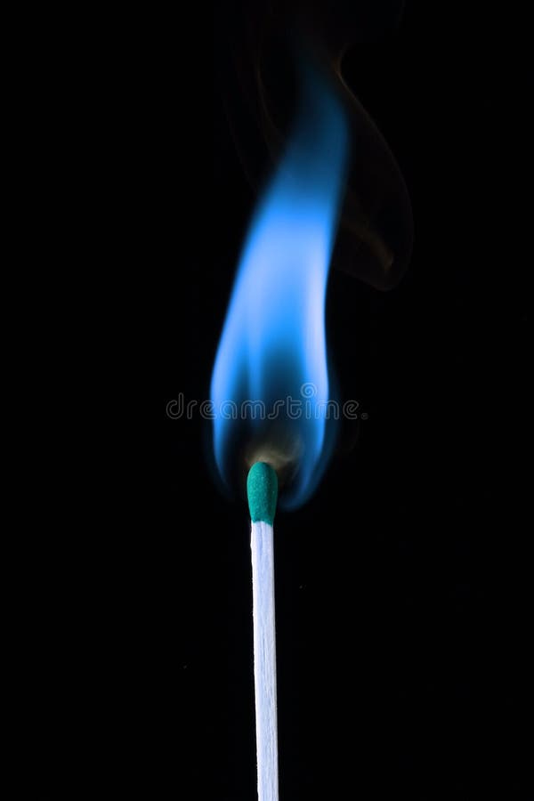 A single wooden match with a blue flame, over black. A single wooden match with a blue flame, over black.