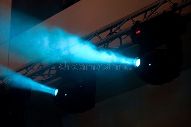 Two separate blue lights spot on a stage with some smoke. Two separate blue lights spot on a stage with some smoke