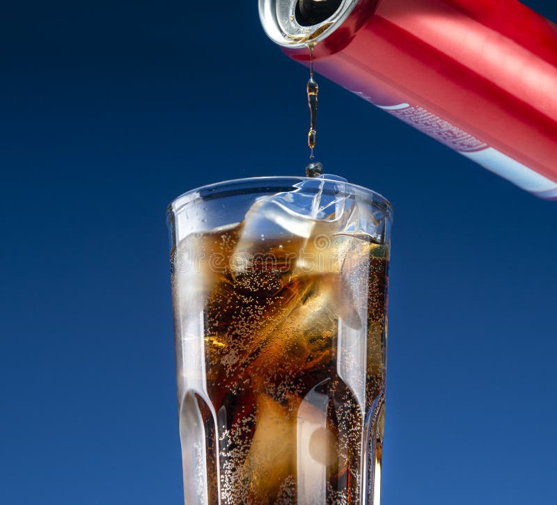 Carbonated drink pours from an aluminum can into a glass. Carbonated drink pours from an aluminum can into a glass