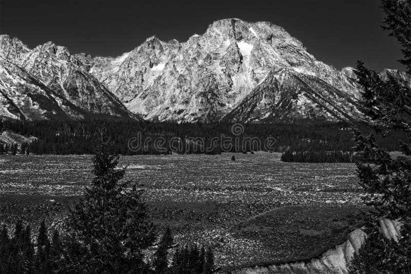 Mt. Moran in the Grand Tetons glowing bright under a dark sky -- monochrome. Mt. Moran in the Grand Tetons glowing bright under a dark sky -- monochrome