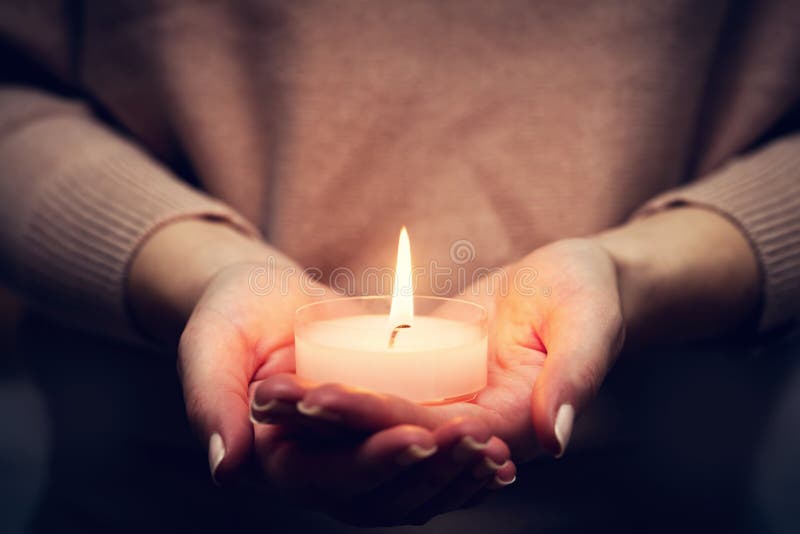 蜡烛轻发光在woman& x27; s手 祈祷，信念，宗教