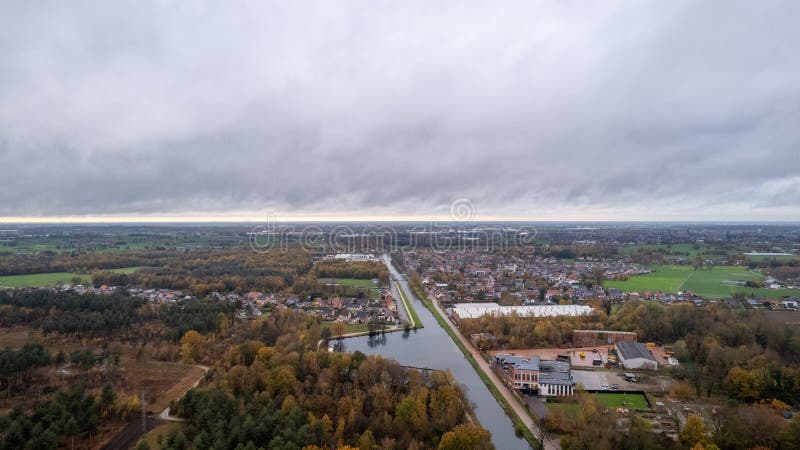 This aerial photograph captures the essence of a rural landscape under a dramatic overcast sky. A winding river cuts through the scene, reflecting the gray tones of the sky above, and is bordered by greenery and trees that hint at the changing seasons. The nearby residential area, with its clustered homes, is interspersed with open fields, suggesting a community that lives in harmony with the surrounding natural environment. The image evokes a tranquil and introspective mood, with the vast expanse of sky and land conveying a sense of openness and quiet solitude. Overcast Sky over a Rural Landscape with Winding River. High quality photo. This aerial photograph captures the essence of a rural landscape under a dramatic overcast sky. A winding river cuts through the scene, reflecting the gray tones of the sky above, and is bordered by greenery and trees that hint at the changing seasons. The nearby residential area, with its clustered homes, is interspersed with open fields, suggesting a community that lives in harmony with the surrounding natural environment. The image evokes a tranquil and introspective mood, with the vast expanse of sky and land conveying a sense of openness and quiet solitude. Overcast Sky over a Rural Landscape with Winding River. High quality photo