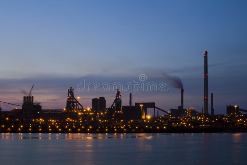 Steelworks at dawn, seen from across a sluice entrance. An industrial, almost silhouette view of heavy industry. This image is part of the collection. Steelworks at dawn, seen from across a sluice entrance. An industrial, almost silhouette view of heavy industry. This image is part of the collection