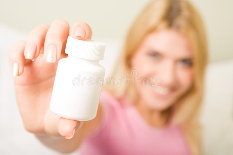 Close-up of femaleï¿½s hand holding plastic pill bottle containing vitamins. Close-up of femaleï¿½s hand holding plastic pill bottle containing vitamins