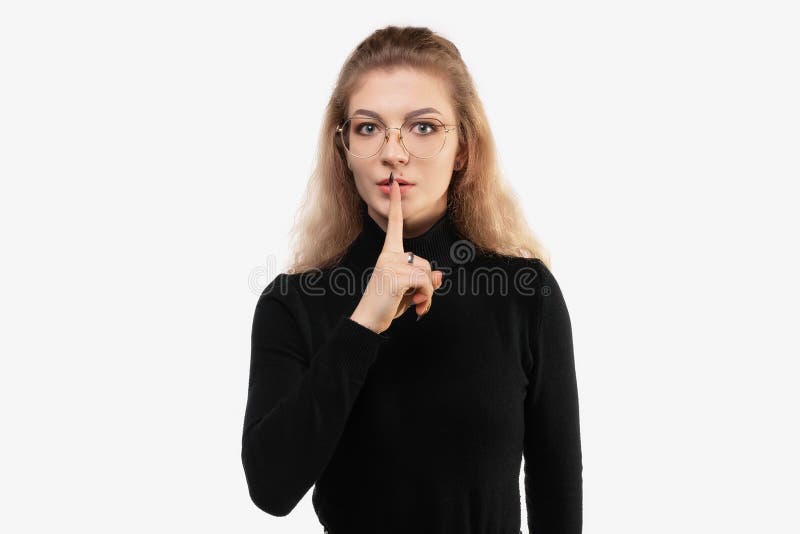 表情严肃的特写女孩，手指压在嘴唇上，要求保持沉默或保持沉默 免版税库存图片