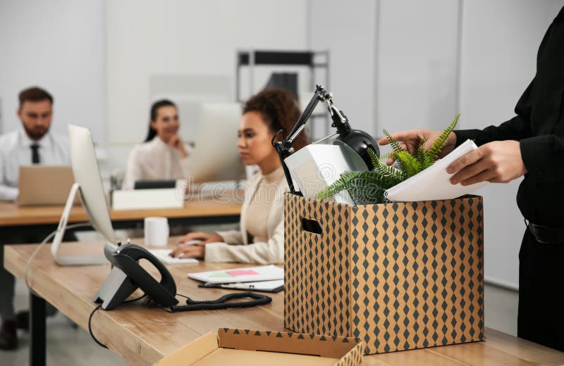 Dismissed men packing stuff into box at office, closeup. Dismissed men packing stuff into box at office, closeup.