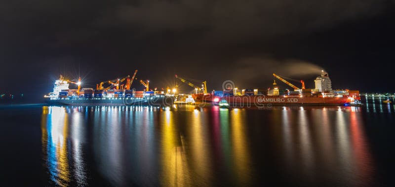 Papeete, French Polynesia - October 2, 2018: Night shot. Papeete port with loading cranes and cargo ships being loaded with containers. Beautiful lights. Long exposure. Papeete, French Polynesia - October 2, 2018: Night shot. Papeete port with loading cranes and cargo ships being loaded with containers. Beautiful lights. Long exposure