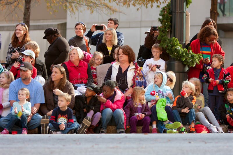 Atlanta, GA, USA - December 1, 2012: Spectators watch from the sidewalk and street curb as the Atlanta Christmas parade takes place down Peachtree Street in downtown Atlanta. Atlanta, GA, USA - December 1, 2012: Spectators watch from the sidewalk and street curb as the Atlanta Christmas parade takes place down Peachtree Street in downtown Atlanta.