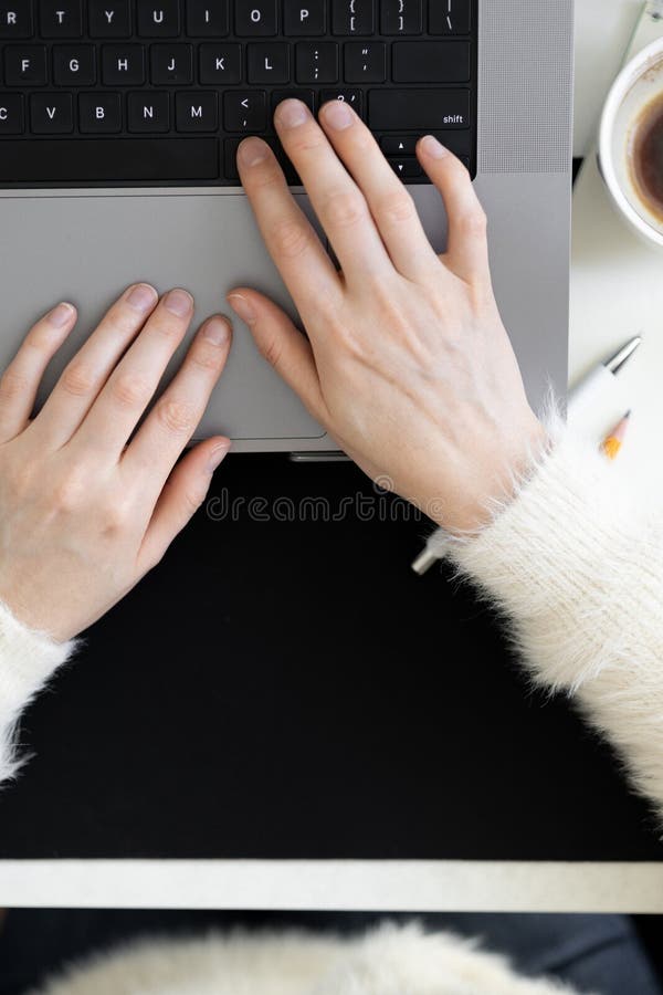 POV: Female hands typing on laptop keyboard. Using internet and modern wireless technology. Blogging, shopping online, overtime working. Top view of office desktop, coffee, stationery. Copy space. POV: Female hands typing on laptop keyboard. Using internet and modern wireless technology. Blogging, shopping online, overtime working. Top view of office desktop, coffee, stationery. Copy space