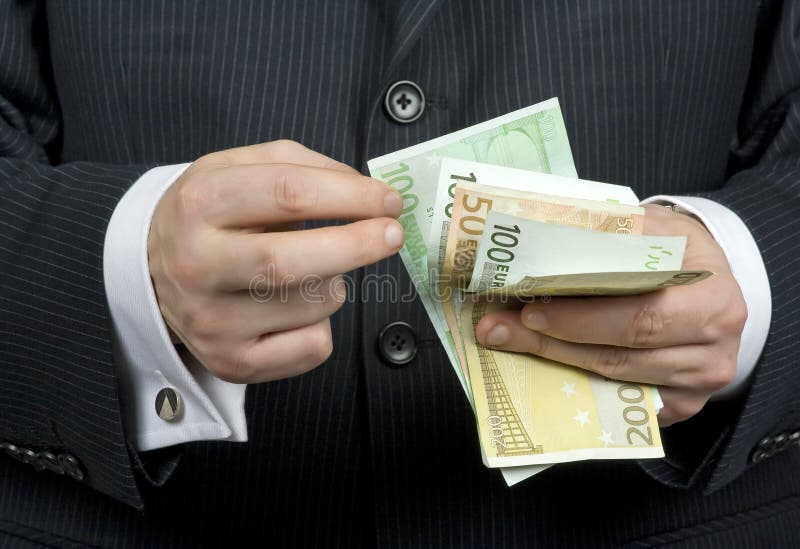 Detail of a businessman hands with money. Detail of a businessman hands with money