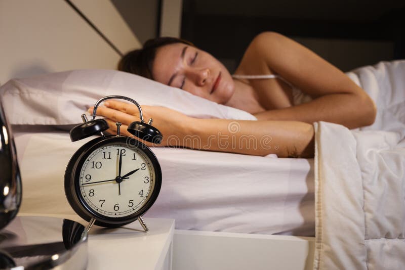 计时展示2 O睡觉在床上的`时钟和妇女
