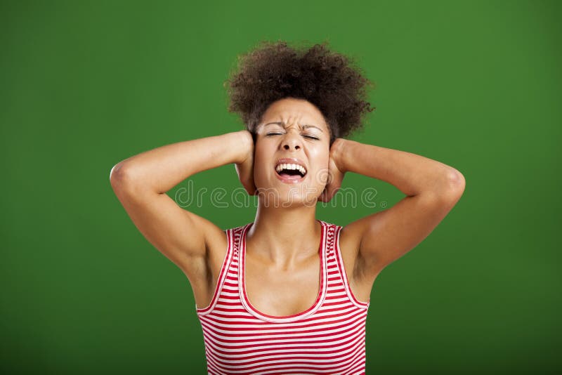 African woman covering ears with her hands, over a green background. African woman covering ears with her hands, over a green background