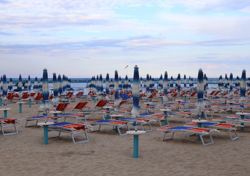 Many closed umbrellas in late summer at the beach. Many closed umbrellas in late summer at the beach