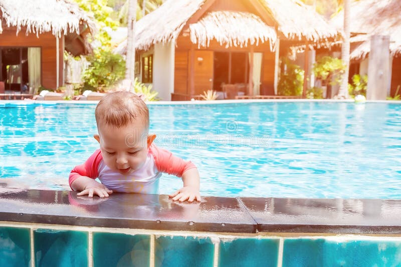 Cute little baby trying to get out of the pool. Cute little baby trying to get out of the pool.