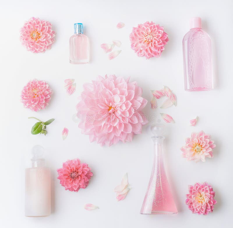 Pastel pink natural cosmetic products setting, flat lay with pretty flowers, top view. Beauty, floral perfume and skin care concept. Pastel pink natural cosmetic products setting, flat lay with pretty flowers, top view. Beauty, floral perfume and skin care concept