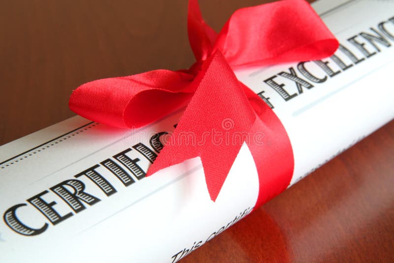 Certificate of excellence with a red ribbon on a wooden desk. Certificate of excellence with a red ribbon on a wooden desk