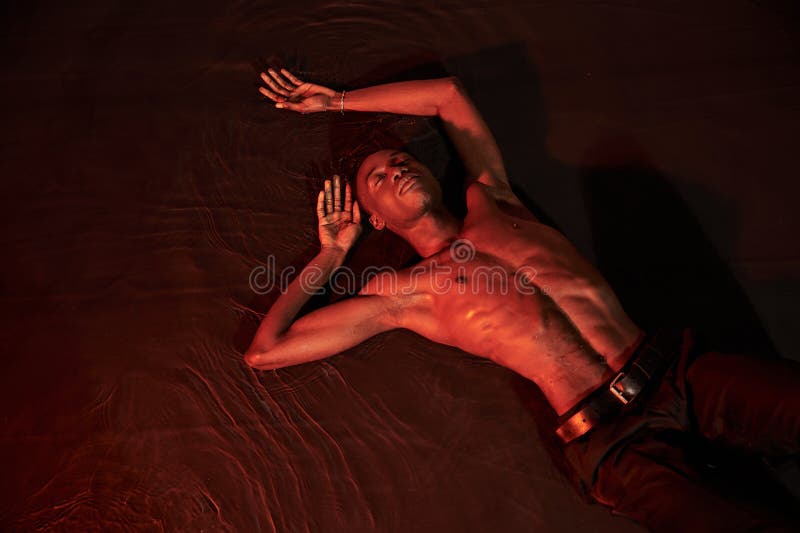 sexy african american man lying topless on water with closed eyes, dark lights, fashion concept, stock photo. sexy african american man lying topless on water with closed eyes, dark lights, fashion concept, stock photo