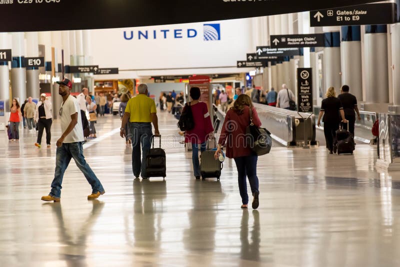 IAH, Houston Intercontinental Airport, Houston, TX, USA - passengers walking with lugagge in airport. IAH, Houston Intercontinental Airport, Houston, TX, USA - passengers walking with lugagge in airport