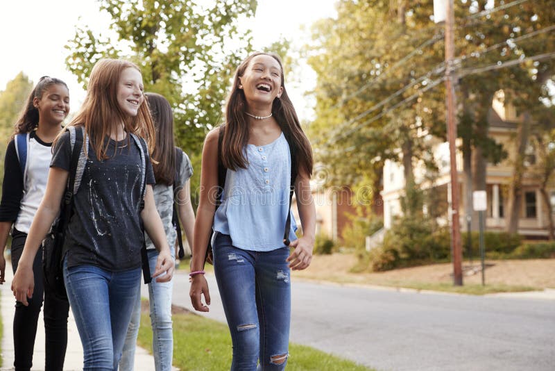 走到学校，正面图关闭的四个青少年女孩 库存图片