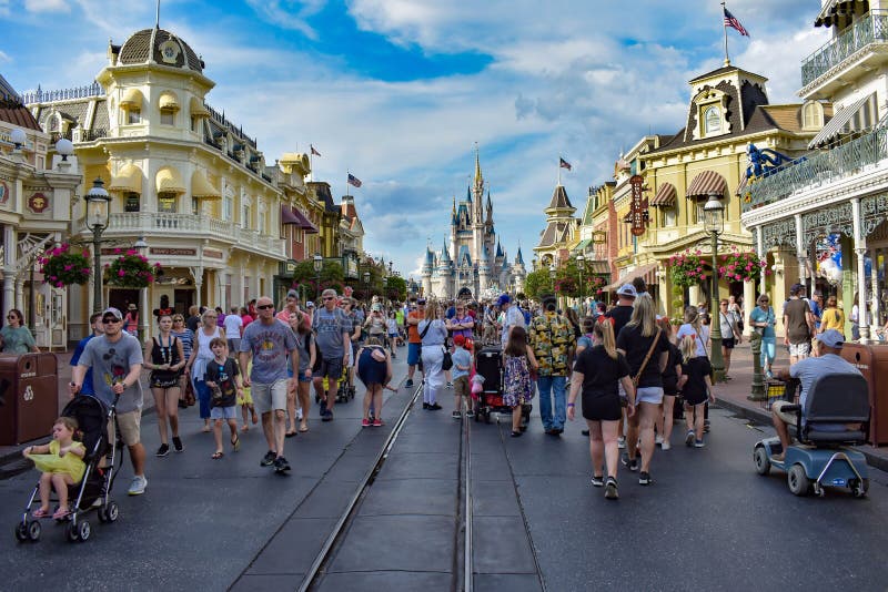 Orlando, Florida. March 19, 2019. People walking on Main Street and Cinderella`s Castle at Walt Disney World . Orlando, Florida. March 19, 2019. People walking on Main Street and Cinderella`s Castle at Walt Disney World .