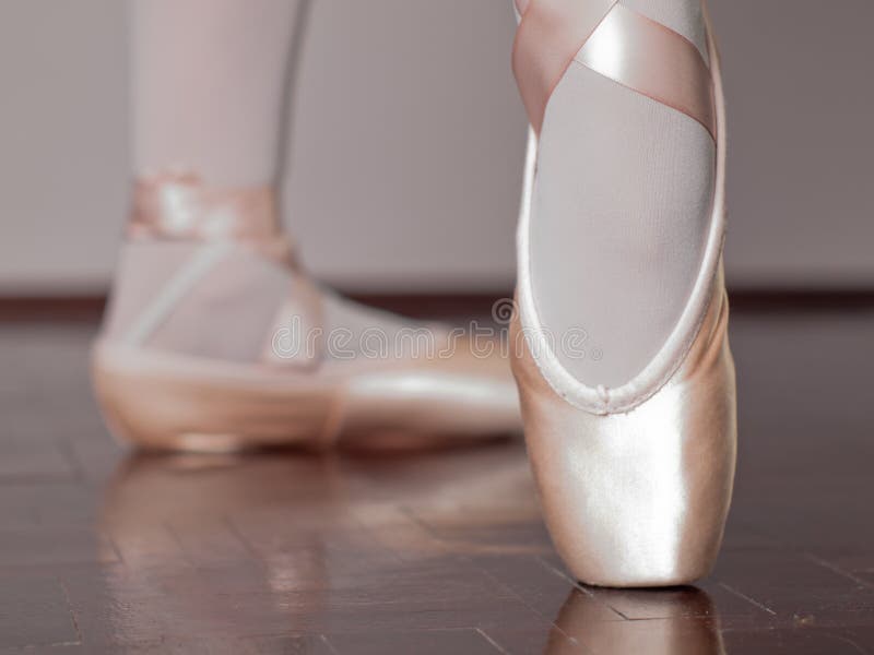 Low angle view of a dancer in ballet shoes dancing in Pointe. Low angle view of a dancer in ballet shoes dancing in Pointe