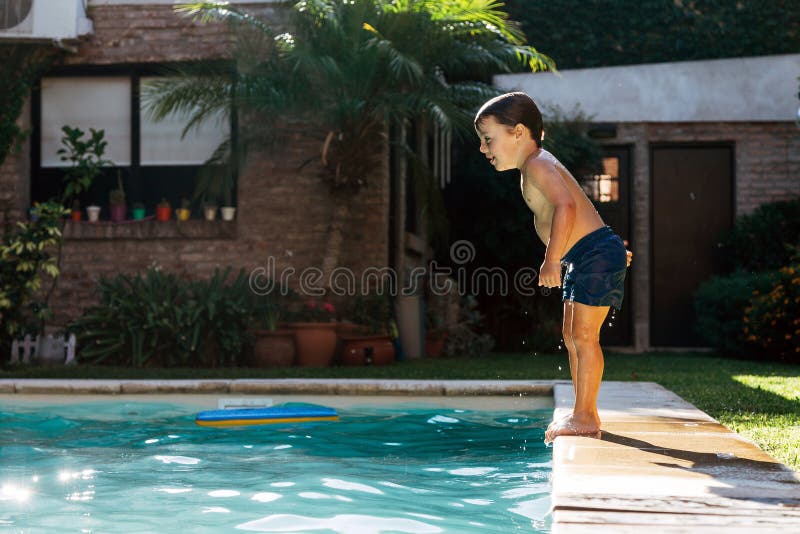 Little boy jumping in a pool. Child get fun in the swimming pool of his home. Little boy jumping in a pool. Child get fun in the swimming pool of his home