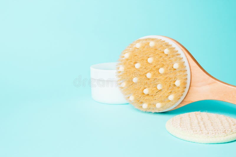 身体与奶油的按摩刷子在蓝色背景 身体的按摩刷子 皮肤护理产品 温泉与自然的按摩刷子 库存照片 身体与奶油的按摩刷子在蓝色背景 身体的按摩刷子 皮肤护理产品 温泉与自然的按摩刷子 库存照片
