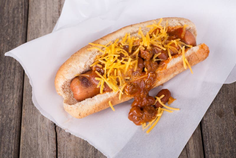 Grilled hot dog on a bun with chili and cheese. Grilled hot dog on a bun with chili and cheese