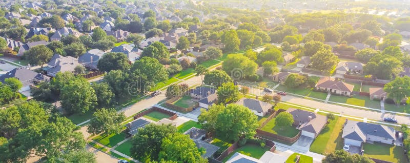 Panoramic Urban sprawl near Dallas, Texas, USA with row of single family houses and large fenced backyard. Aerial view residential neighborhood subdivision surrounded by mature trees. Panoramic Urban sprawl near Dallas, Texas, USA with row of single family houses and large fenced backyard. Aerial view residential neighborhood subdivision surrounded by mature trees