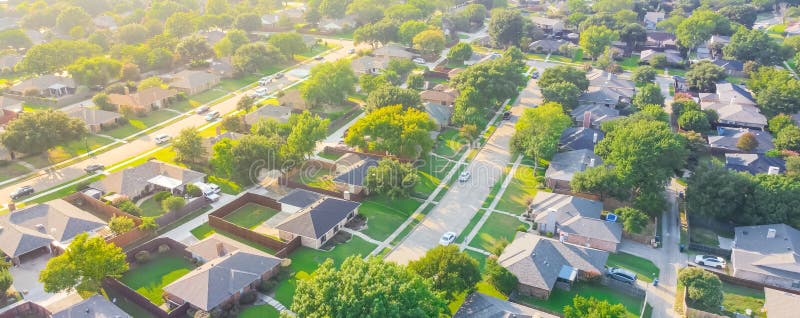 Panoramic Urban sprawl near Dallas, Texas, USA with row of single family houses and large fenced backyard. Aerial view residential neighborhood subdivision surrounded by mature trees. Panoramic Urban sprawl near Dallas, Texas, USA with row of single family houses and large fenced backyard. Aerial view residential neighborhood subdivision surrounded by mature trees