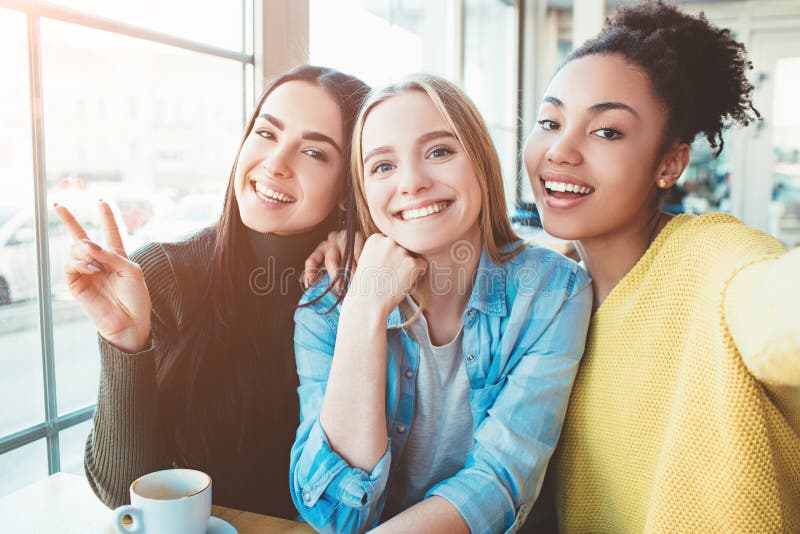 这是的树美丽的女孩selfie同时看很惊人和愉快 在咖啡馆喝一些的他们 免版税图库摄影 这是的树美丽的女孩selfie同时看很惊人和愉快 在咖啡馆喝一些的他们 免版税图库摄影