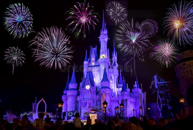 Disney`s Magic Kingdom Cinderella castle at night, lit in purple colors with fireworks. Disney`s Magic Kingdom Cinderella castle at night, lit in purple colors with fireworks