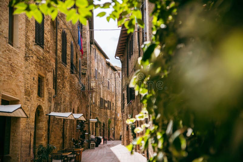 迷人的的中世纪意大利街道，拥有质朴的建筑、户外咖啡馆和茂盛的绿植，营造出宁静的氛围。意大利 库存图片