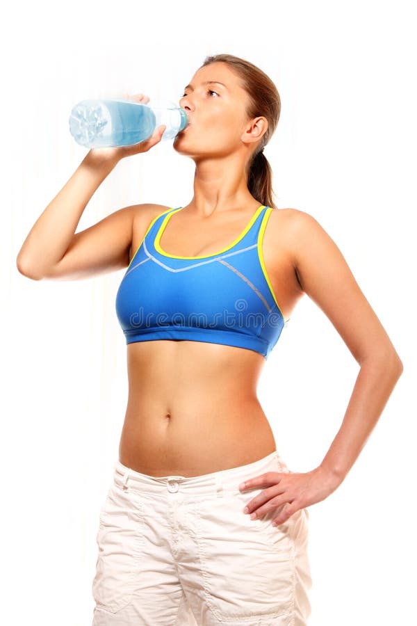 A fit young woman drinking water from a bottle. A fit young woman drinking water from a bottle