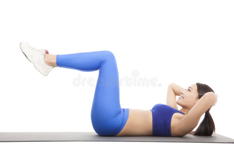 Fit blonde doing pilates core exercise on yoga pad in studio. Fit blonde doing pilates core exercise on yoga pad in studio