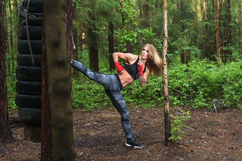 适合的解决女孩敲打高腿边的反撞力户外 妇女战斗机行使,做kickboxing的训练武术 库存图片 适合的解决女孩敲打高腿边的反撞力户外 妇女战斗机行使,做kickboxing的训练武术 库存图片