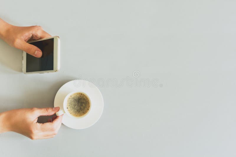 递使用在灰色木桌上的妇女巧妙的电话 咖啡更多时间 早晨仪式 免版税库存照片 递使用在灰色木桌上的妇女巧妙的电话 咖啡更多时间 早晨仪式 免版税库存照片